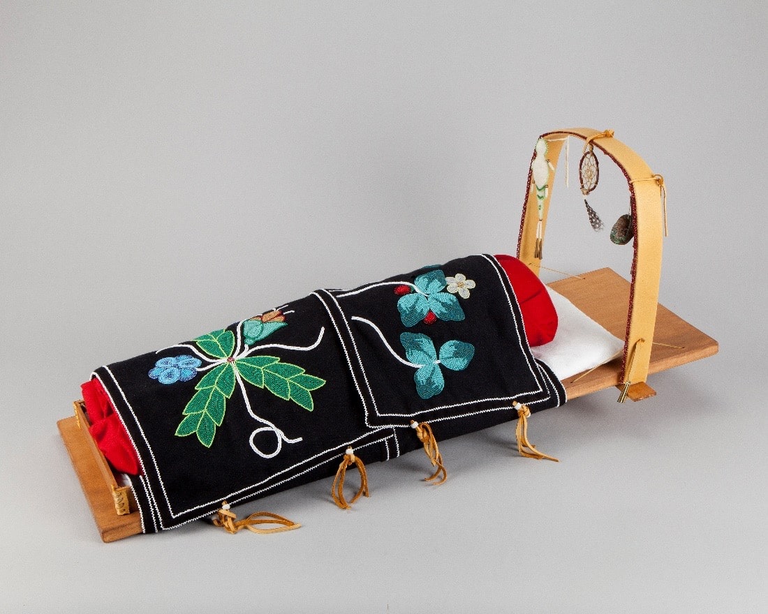 handmade doll cradle with beaded blanket