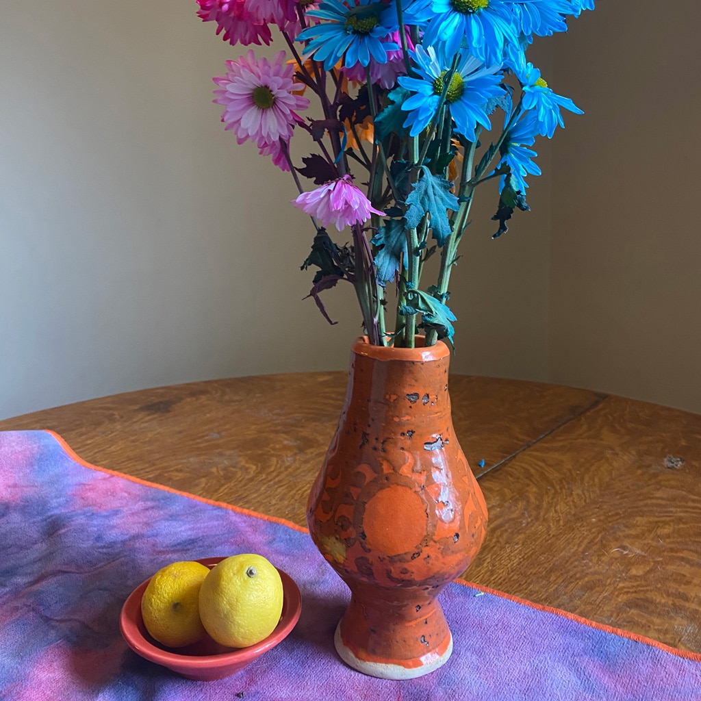 Bowl with lemons and vase of pink and blue flowers